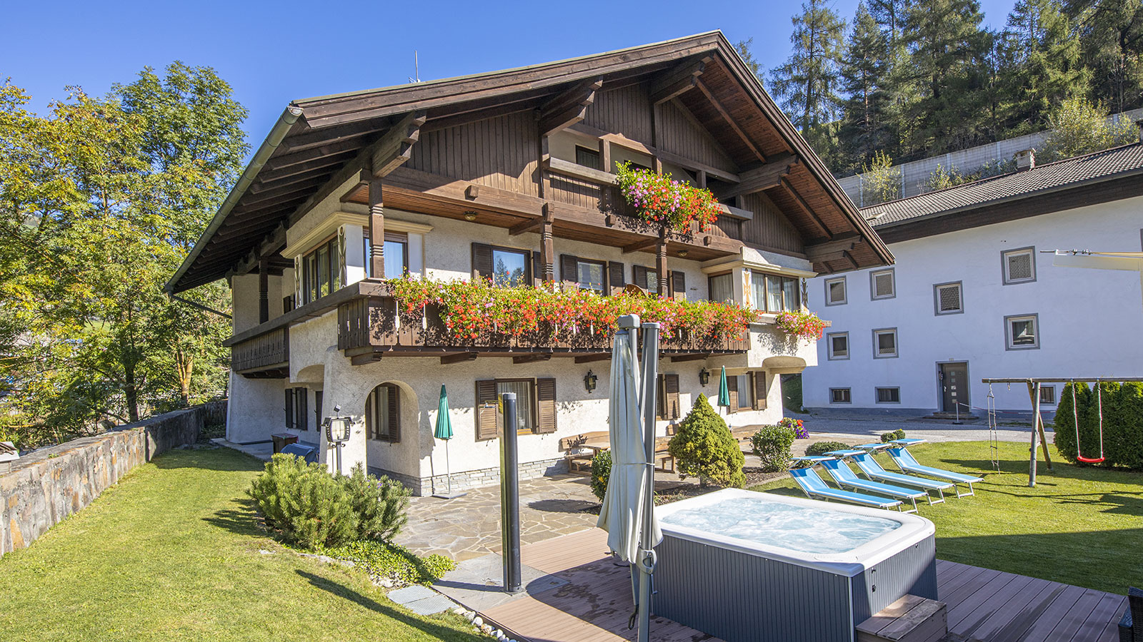 Blick auf den Garten mit Außenpool eines der Ferienwohnungen in Sterzing