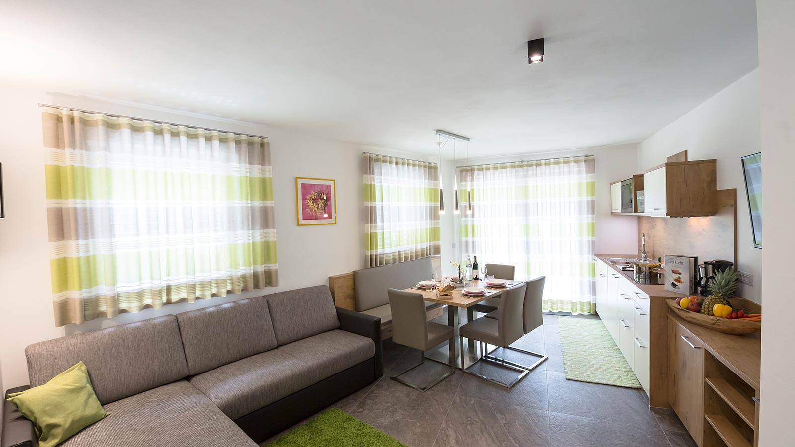 Blick auf die Küche und das Wohnzimmer einer der Ferienwohnungen des Hotels Maibad
